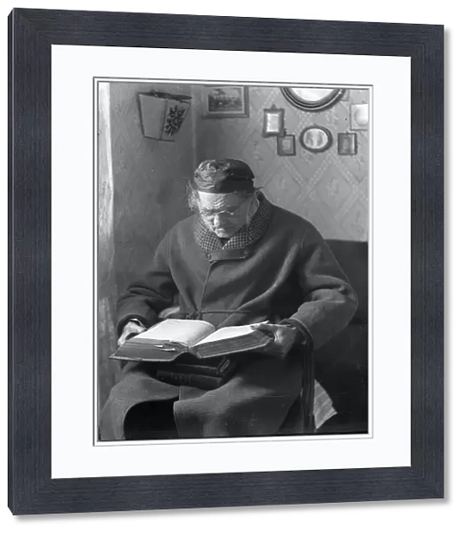 An elderly man sits and reads a book, 1880-1910. Creator: Johan Severin Nilson