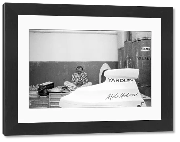 Formula One World Championship: Fourth placed Mike Hailwood McLaren relaxes reading a magazine in the McLaren garage