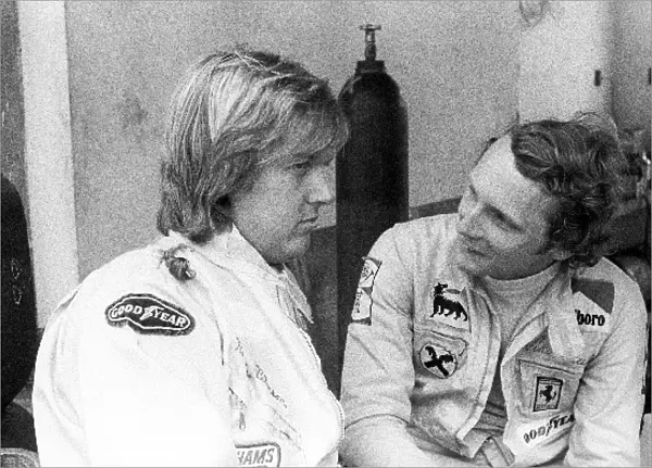 Formula One World Championship: sixth placed Ronnie Peterson Lotus talks with Niki Lauda Ferrari, who retired from the race on lap 4 with a
