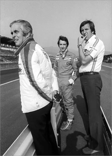 Formula One World Championship: Roger Penske Penske Team Owner stands on the pit wall with race retiree John Watson Penske, and Heinz Hofer