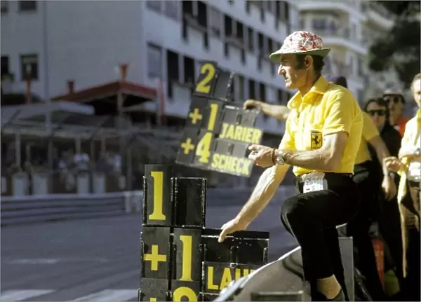 Formula One World Championship: A Ferrari mechanic holds out the pit board for Clay Regazzoni Ferrari, who led the opening laps before spinning on lap 21