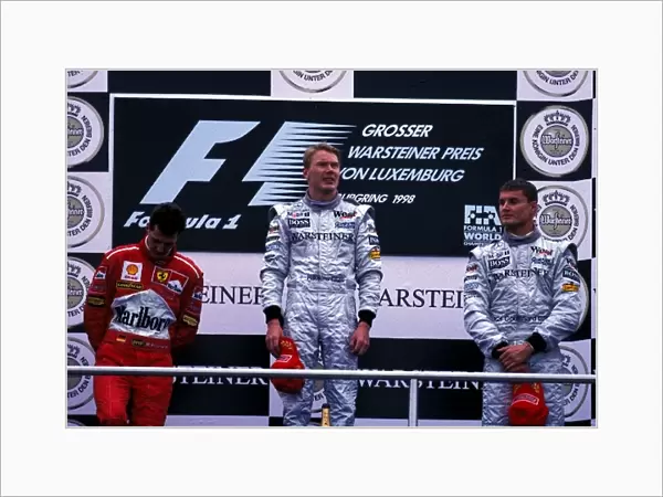 Formula One World Championship: The podium finishers Michael Schumacher Ferrari 2nd, Mika Hakkinen 1st, David Coulthard McLaren 3rd