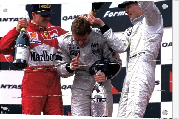 Formula One World Championship: The podium finishers Michael Schumacher Ferrari 2nd, David Coulthard McLaren 1st, Mika Hakkinen McLaren 3rd