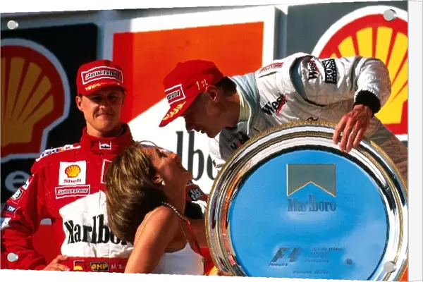 Formula One World Championship: Winner Mika Hakkinen is congratulated by Ayrton Sennas sister Vivianne as 2nd place Schumacher looks