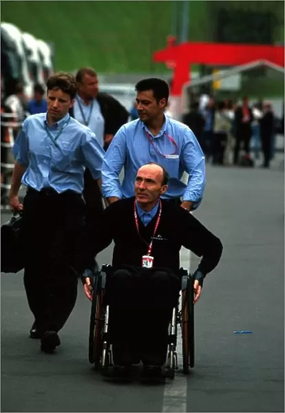 Formula One World Championship: Frank Williams and team personnel in the paddock
