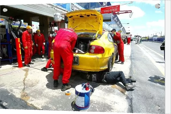 f2371. Mechanics work on the yellow Monaro, which lost the lead to the