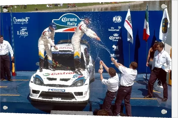 FIA World Rally Championship: Michael Park and Markko Martin Ford Focus RS WRC 03 celebrate victory on the podium with members of the Ford Team