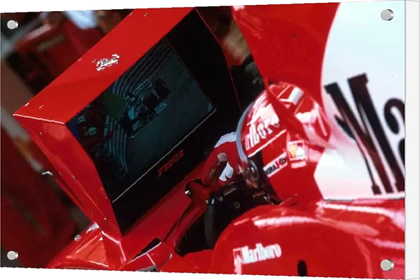Formula One World Championship: Second placed finisher Michael Schumacher Ferrari F2002 watches Eddie Irvine Jaguar R3 crash into the barriers