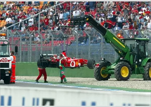 Formula One World Championship: The Ferrari F2002 of Rubens Barrichello is removed from the track after he spun off at the final corner at the