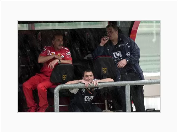 Formula One World Championship: Ferrari and Williams engineers shelter from the rain