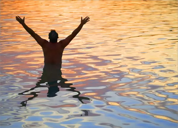 Man In Water Lifting Hands Towards Heaven