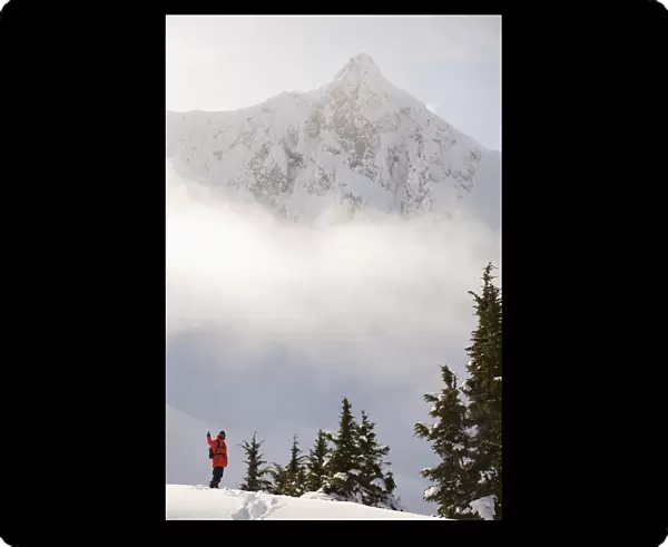 Snowboarder On A Ridge With Scenic Mountains And Fog In The Background, Haines, Southeast Alaska