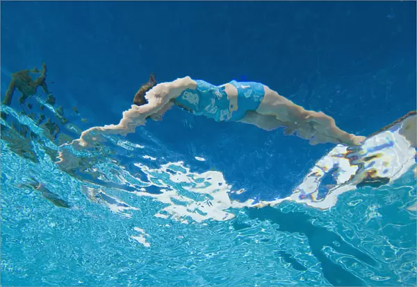 Underwater View Of Woman Diving Into Pool