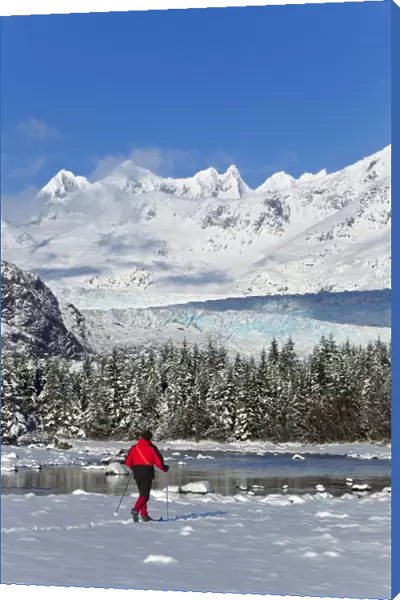 Person Cross-Country Skiing In A Winter Landscape At Mendenhall River With Mendenhall Glacier And Towers In The Background, Tongass National Forest, Southeast Alaska