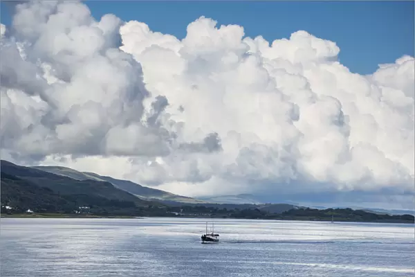Billowing Cloud And A Boat In The Ocean Off The Coast; Isle Of Mull, Argyll And Bute, Scotland