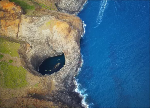 Aerial View Of The Rugged Coastline And Tide Pool In A Hole Along An Hawaiian Island; Na Pali Coast Of Kauai, Hawaii, United States Of America