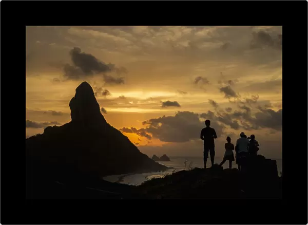 Brazil, Pernambuco, People admiring sunset over Morro do Pico from Forte dos Remedios; Fernando de Noronha