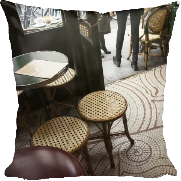 Looking Down At The Floor Of A Parisian Cafe With Small Square Tiles, Traditional Tables And Stools, And The Wooden Bar; Paris, France