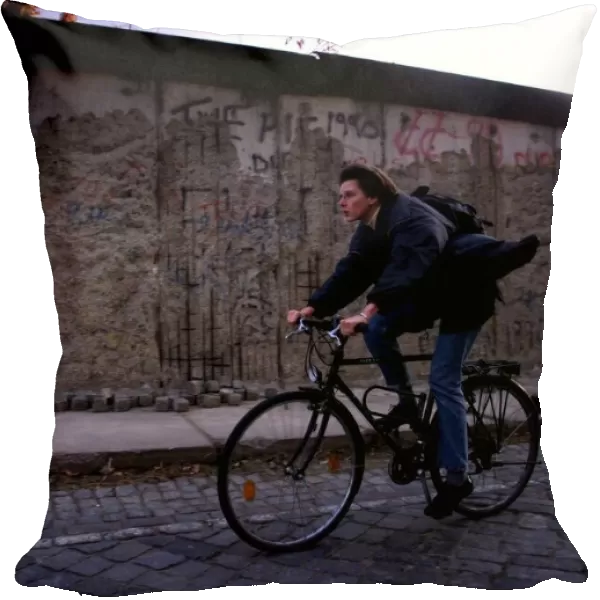 Berlin ten years after the wall a man is seen cycling by