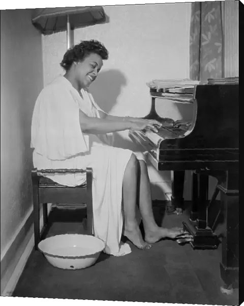 Winifred Atwell, pianist, seen here rehearsing after warming up both her hands and feet