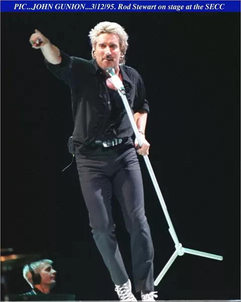 Rod Stewart dancing with the mike on stage at the SECC in Glasgow pointing