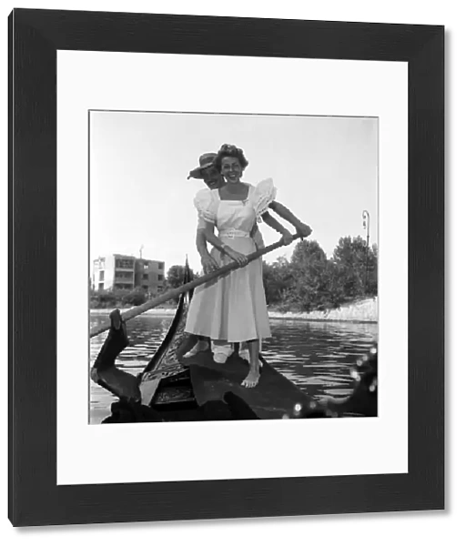 Ann French, actress posing with a gondolier in Venice, Italy. September 1952 C4555