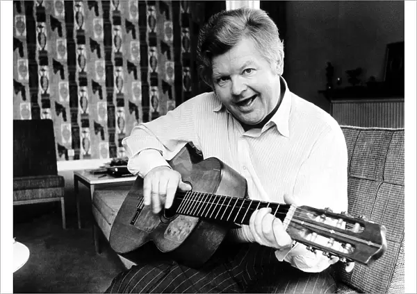 Benny Hill at home playing his guitar 1979