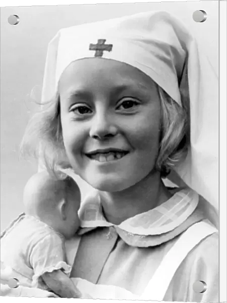 Young girl wearing a nurse costume holding her toy doll Circa 1945 P044505