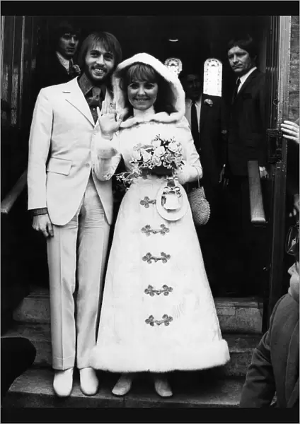 Pop singer Lulu wearing a maxi dress as she poses with the groom Maurice Gibb of the Bee