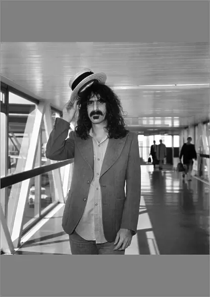 Rock Star Frank Zappa complete with straw boater hat at Londons Heathrow airport