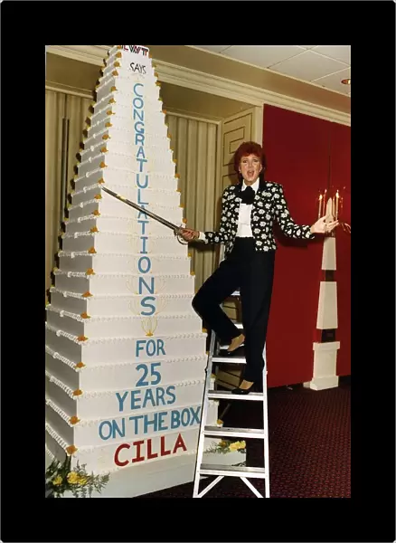 Cilla Black on a step ladder about to cut her cake with a sword celebrating her 25