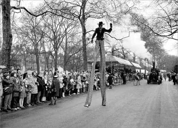 A stilt walker taking part in the Easter parade, Battersea Park. March 1975 75-1706-010