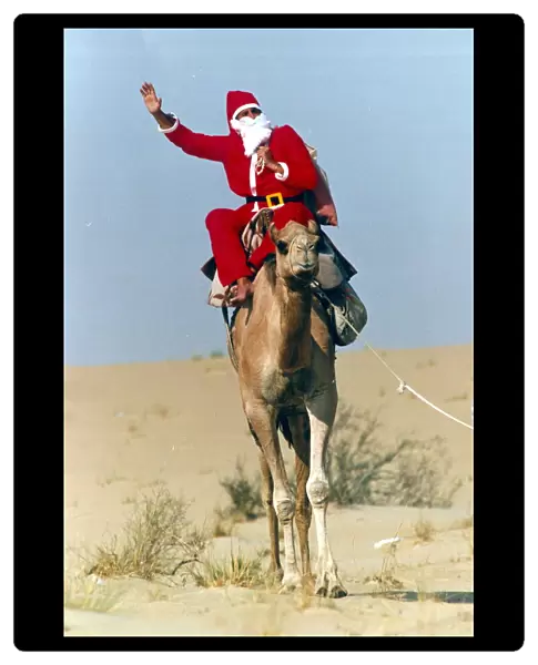 Santa Claus waves from atop his camel in the desert on his way to delivering a message to