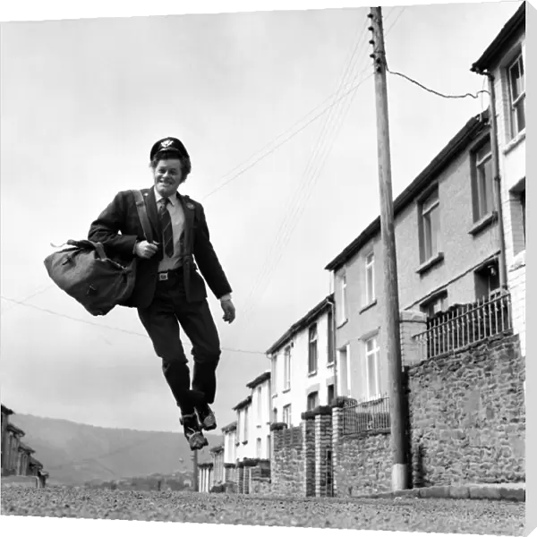 Postman Mr. Fred Henderson in happy mood as he delivers his mail. April 1975