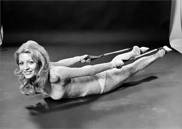Woman lying on the floor doing slimming exercises. January 1971