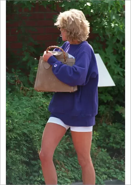 Princess Diana holding a key ring in her mouth, turns her head away as she leaves her gym