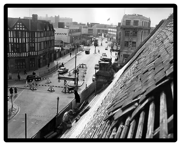 This unusual view of Corporation Street, Coventry, is taken as workmen repair the roof of