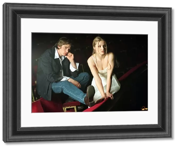 Model couple sitting on red cinema seats
