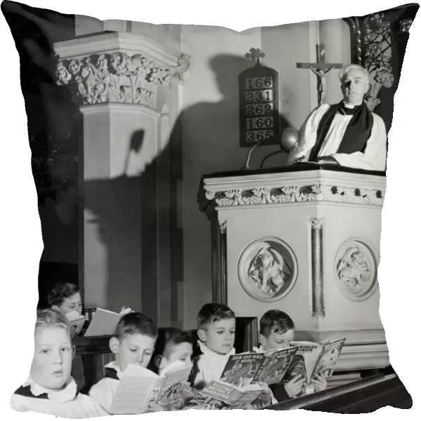 Choirboys reading their books in church during a priests sermon Circa 1954
