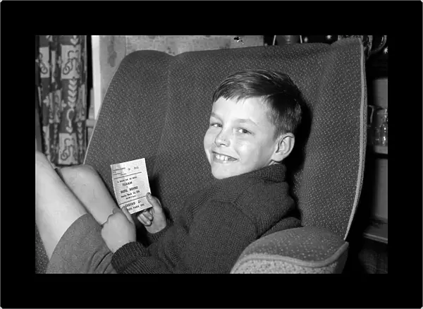 A young Fulham fan holds his ticket for the FA Cup 6th round match against Bristol Rovers