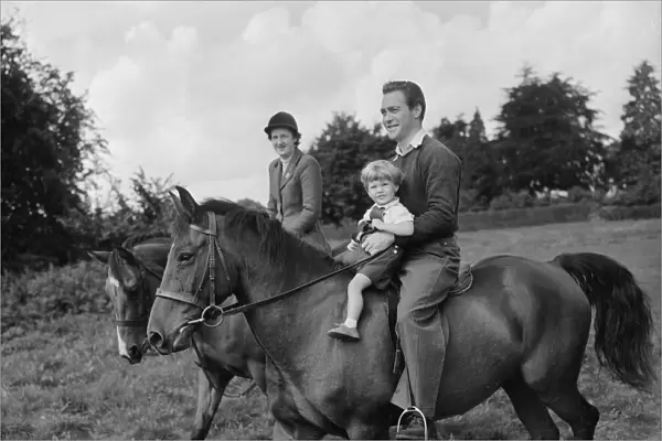 Actor Richard Todd playing with his son Peter on horseback at home