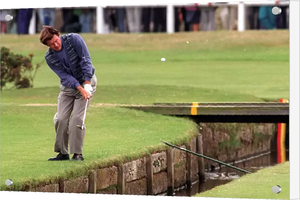 Nick Faldo plays over the Swilken burn at the 1st after putting his ball in the water in