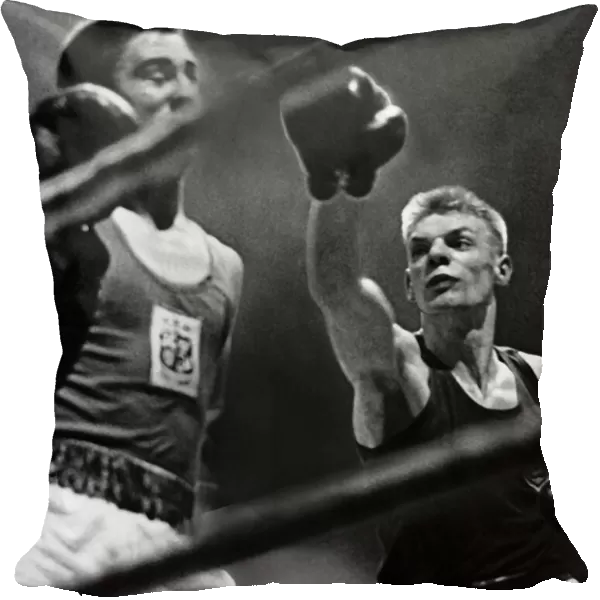 Dick McTaggart boxer throwing punch boxing during fight against ropes. Circa 1958