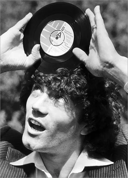 Footballer Kevin Keegan with the record he has cut called Head over Heels in Love