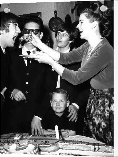 John Lennon being fed birthday cake by Claudette Orbison while her husband Roy