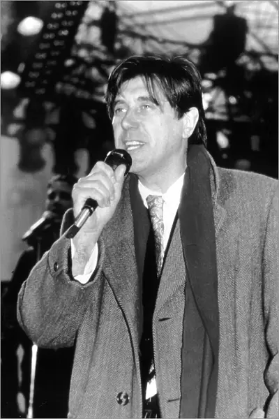 Bryan Ferry Singer with Pop Group Roxy Music singing on stage wearing overcoat and scarf