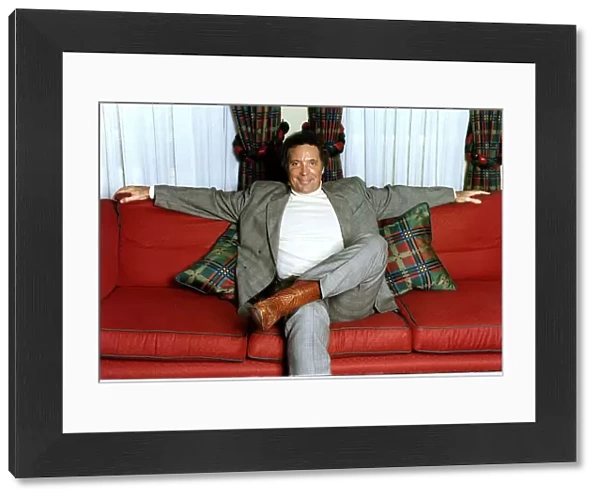 Tom Jones Singer sitting on a couch