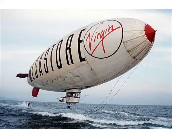 Virgin Airship - A man water skis behind an airship flying low over the sea