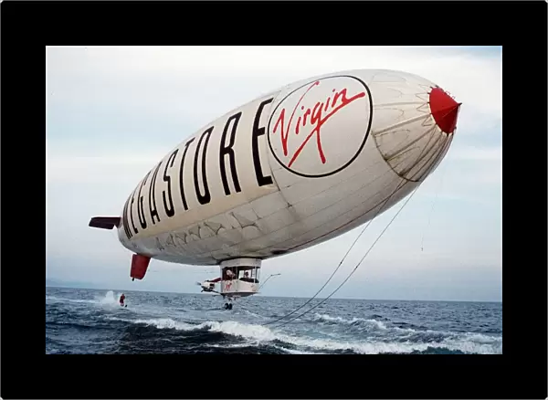 Virgin Airship - A man water skis behind an airship flying low over the sea