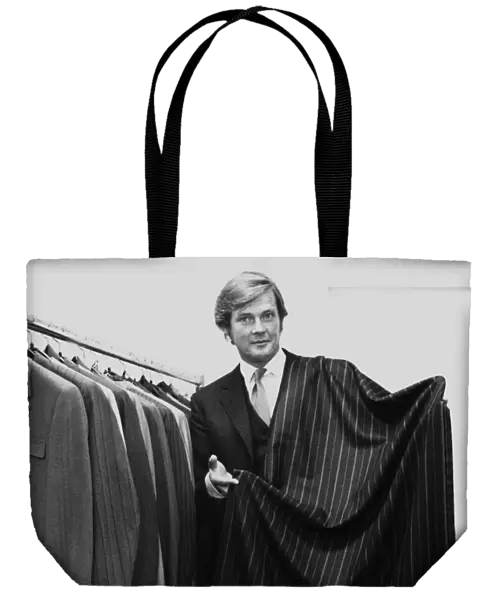 Roger Moore actor holding a length of suiting cloth October 1970 he is a director of
